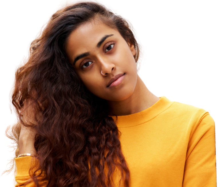 Portrait of a young African American woman tilting her head and holding her hair and wearing a yellow sweater and smirking. She is seeking an abortion clinic in Detroit MI.