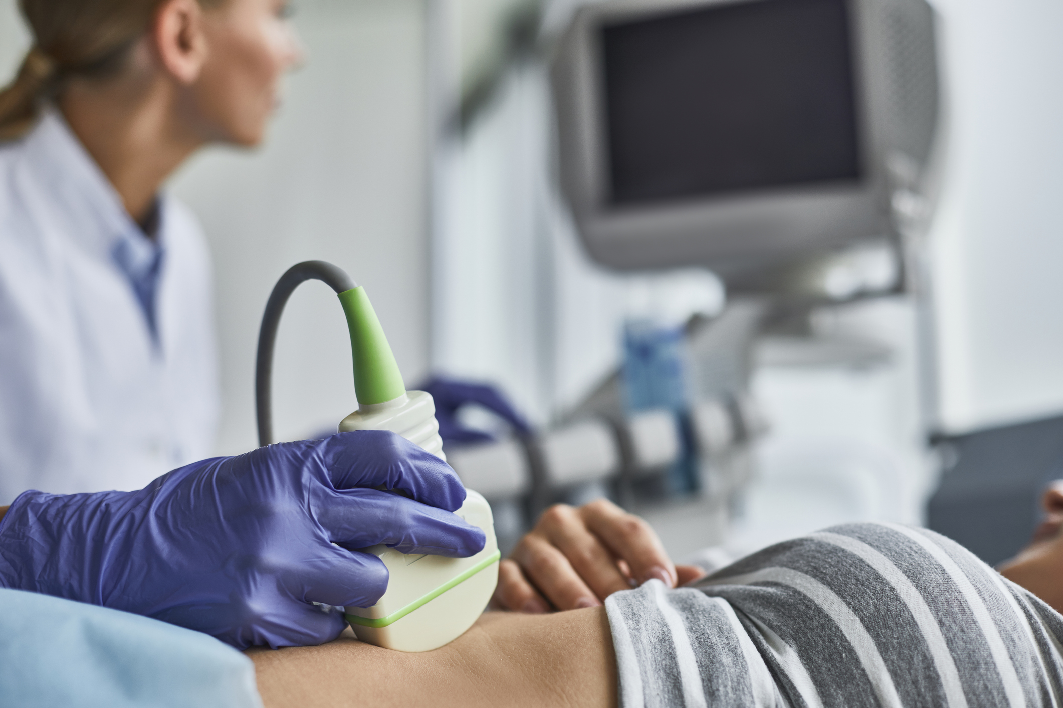 Doctor checking woman pregnancy during ultrasound examination