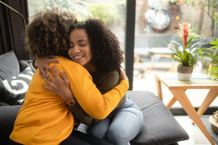 Two black women hugging - Symbolizing support and care in free pregnancy services at our About Us page.