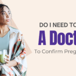 Black woman holding a phone and green smoothie, looking thoughtful — wondering if she needs to see a doctor to confirm pregnancy in Detroit or Southfield, Michigan.