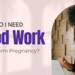Black woman in glasses working at a laptop, appearing focused — researching whether she needs blood work to confirm pregnancy near Southfield, MI.