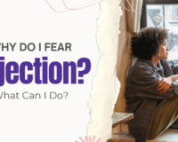 Young Black woman sitting by a window looking out with a concerned expression — struggling with fear of rejection during pregnancy in Detroit, MI.