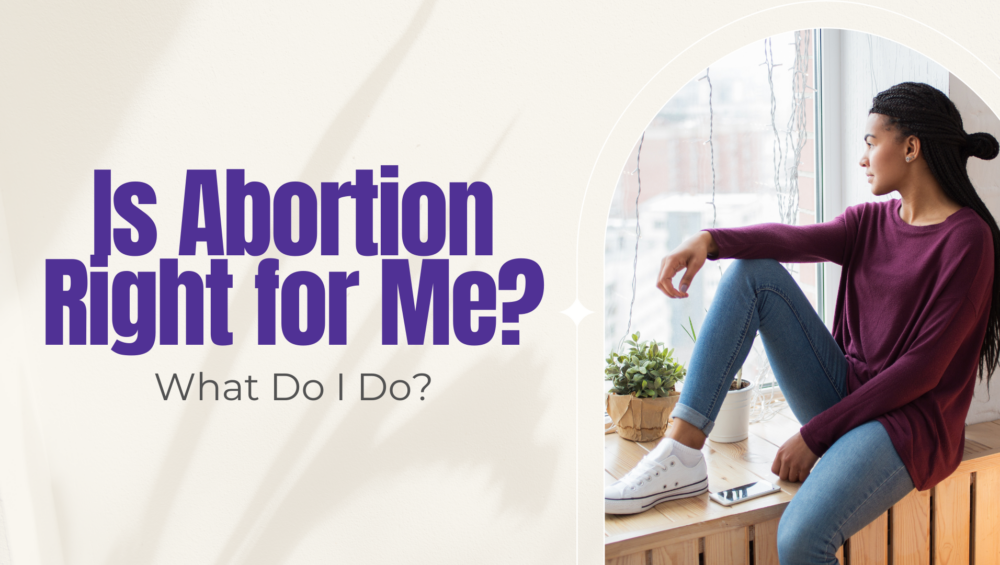 Young woman in a maroon sweater sitting at a window with a phone nearby — thinking about whether abortion is the right choice in Detroit.