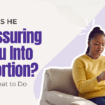 woman in her living room looks uncertain and concerned as her partner texts her about having an abortion.